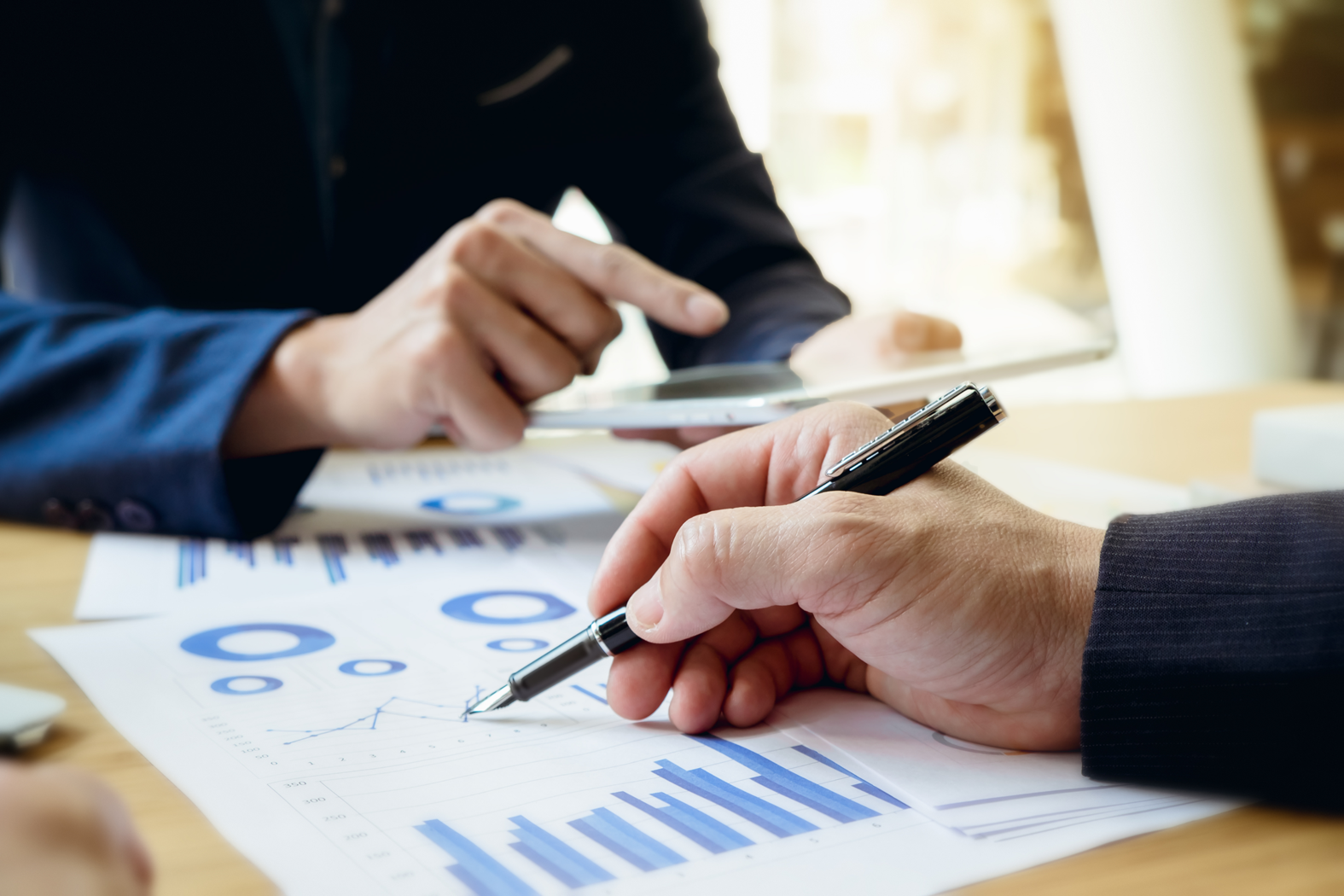 Business professionals reviewing financial reports and charts during an investor meeting, analyzing data and discussing startup funding strategy.